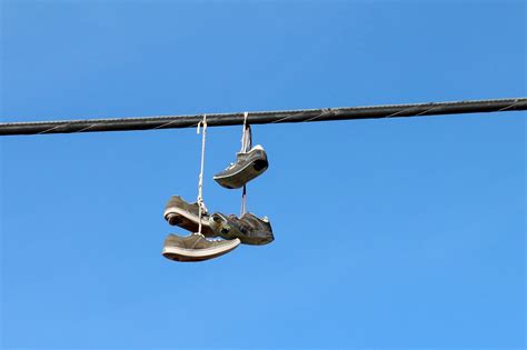 why do people throw shoes over power lines